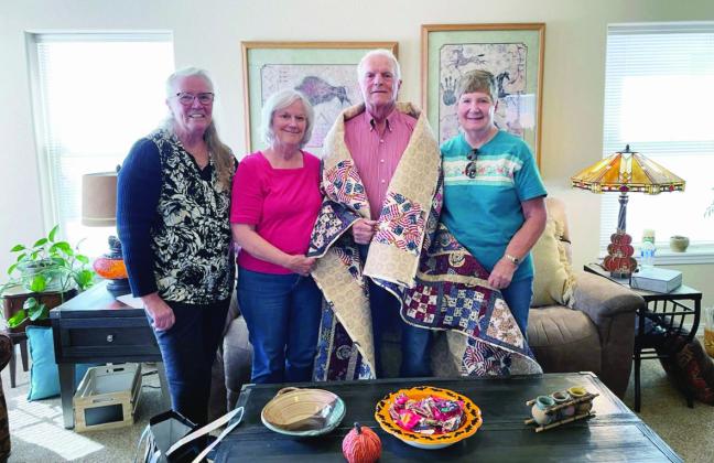 Scrappy Ladies Quilt Guild members Rosemary Holland, Deb Berringer, and Nancy Shaw (L-R) participate in presenting Veteran Stan Abel with a Valor Quilt. Courtesy Photo